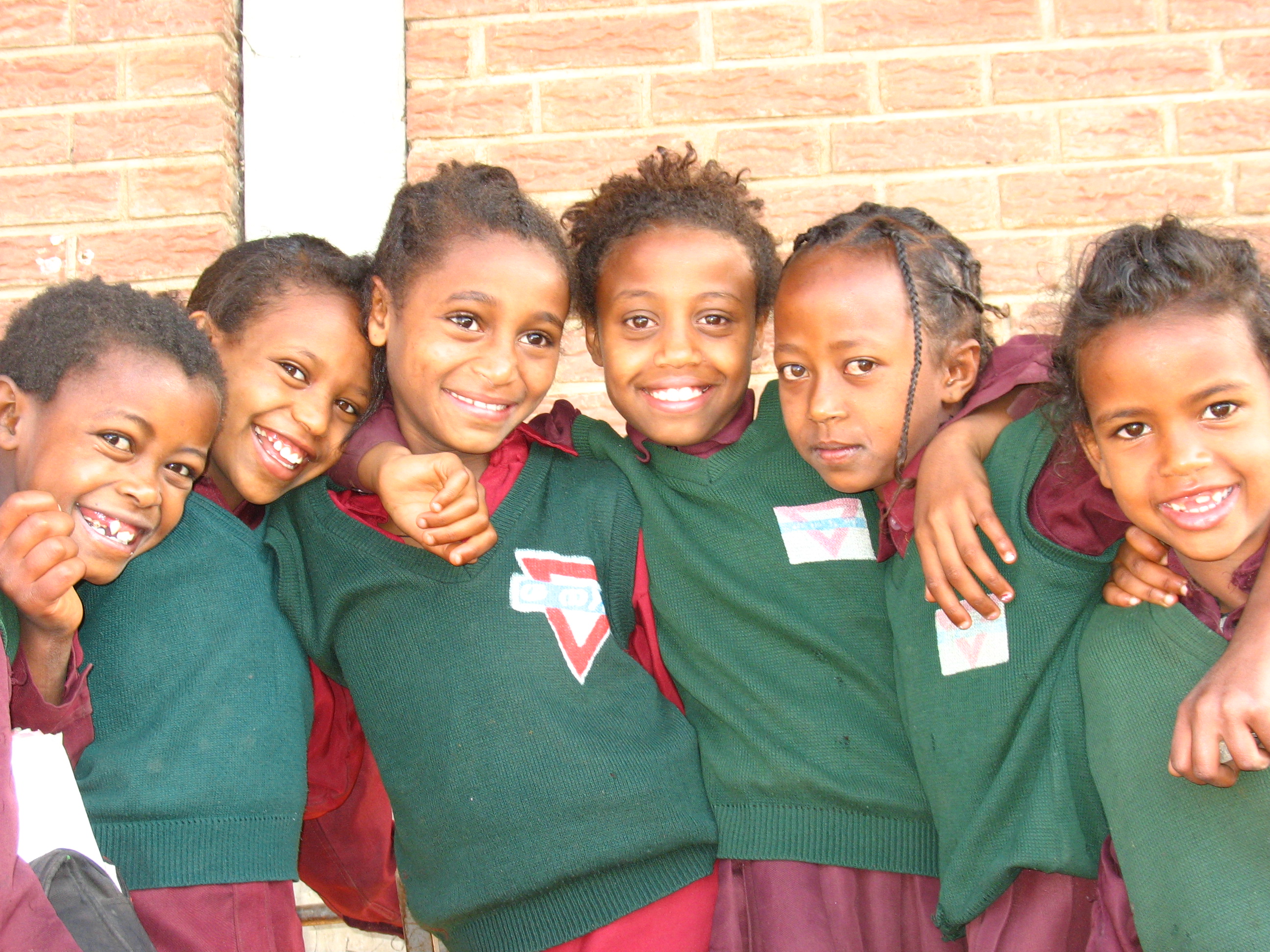 Smiling children with their arms around each other