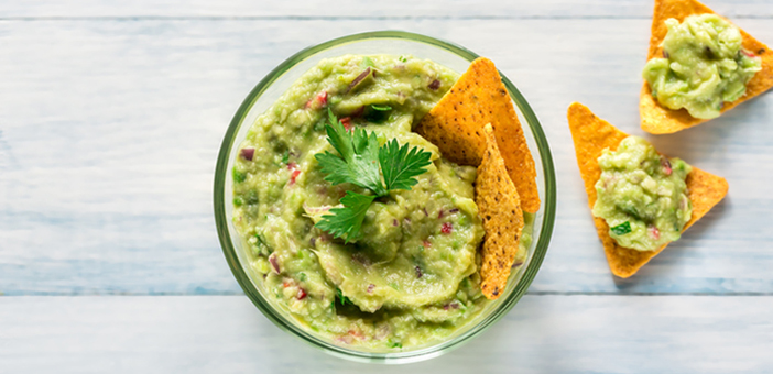 Greek yogurt guacamole and chips in a bowl