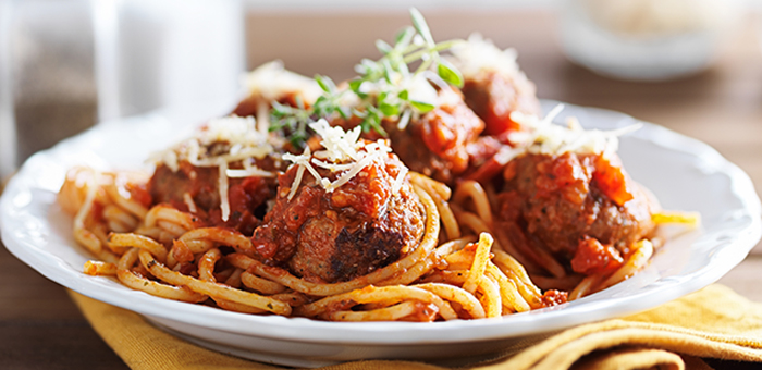Spaghetti and meatballs in a white bowl