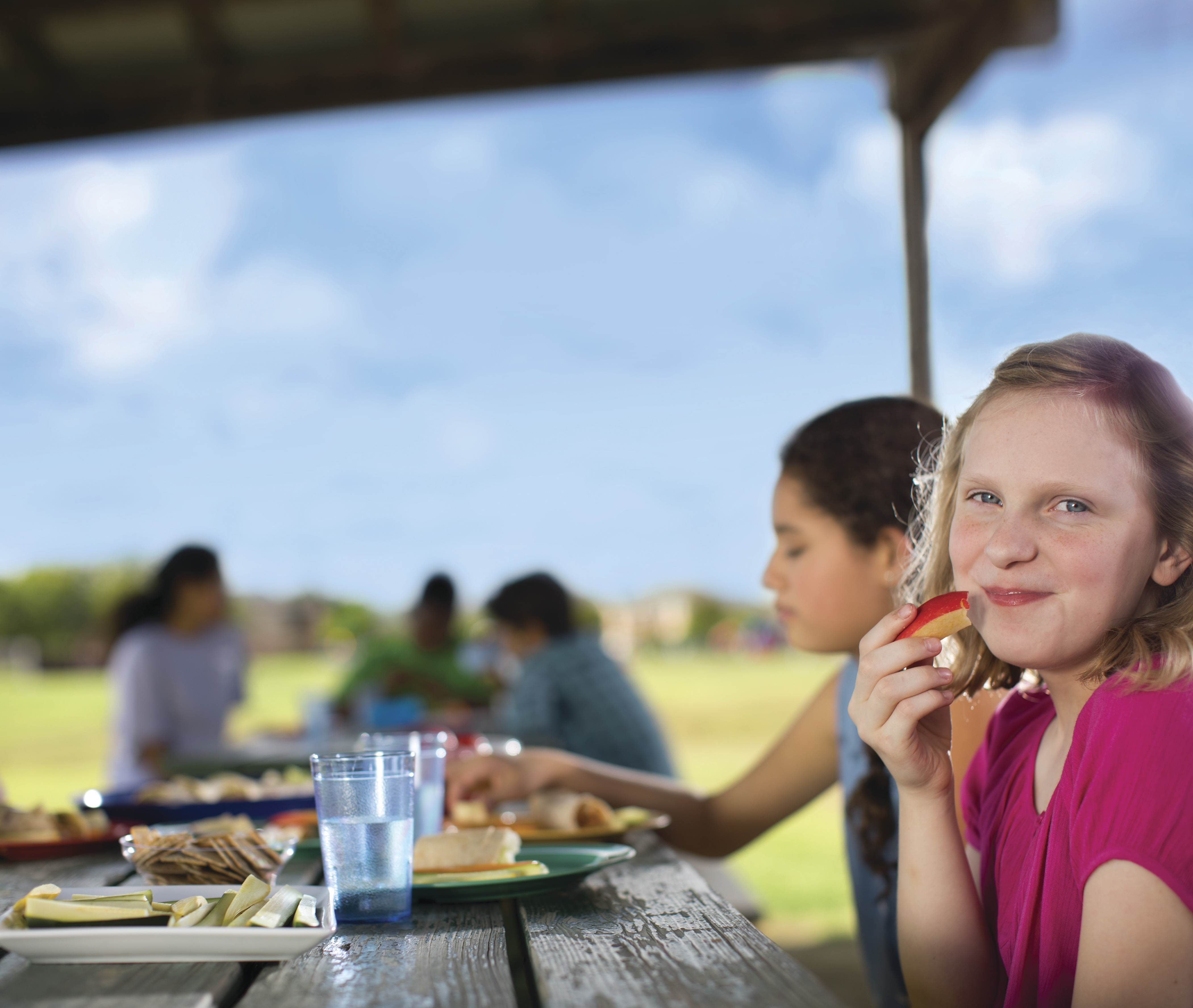 Children eating outdoors at picnic table