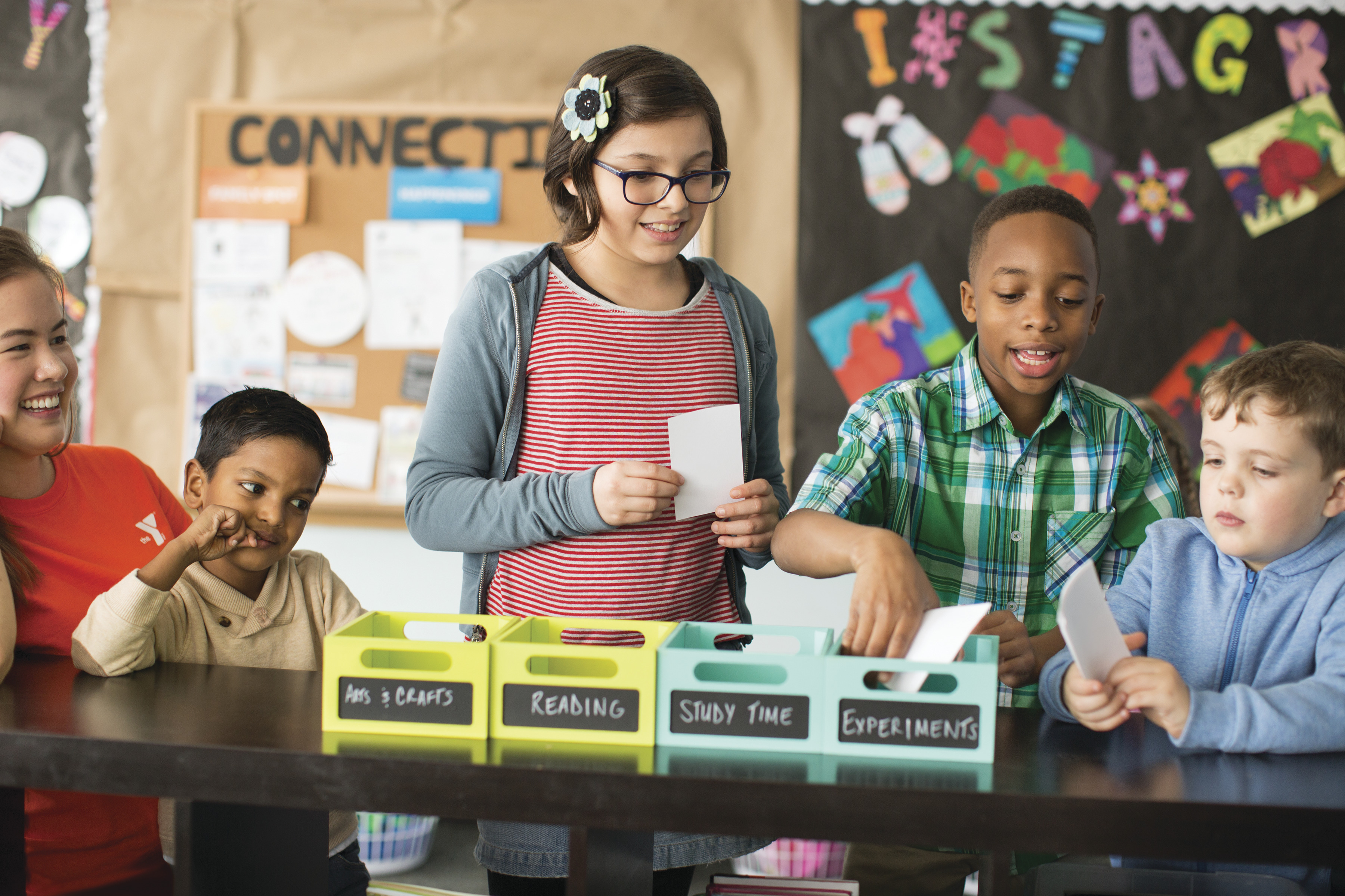 Children organizing index cards according to academic subjects at YMCA