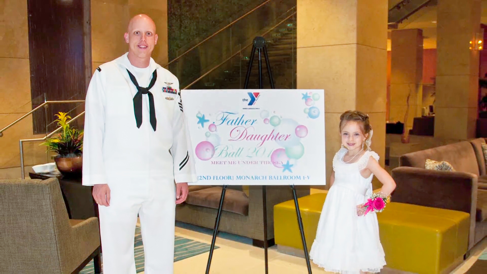 Man and daughter pose during YMCA military outeach event