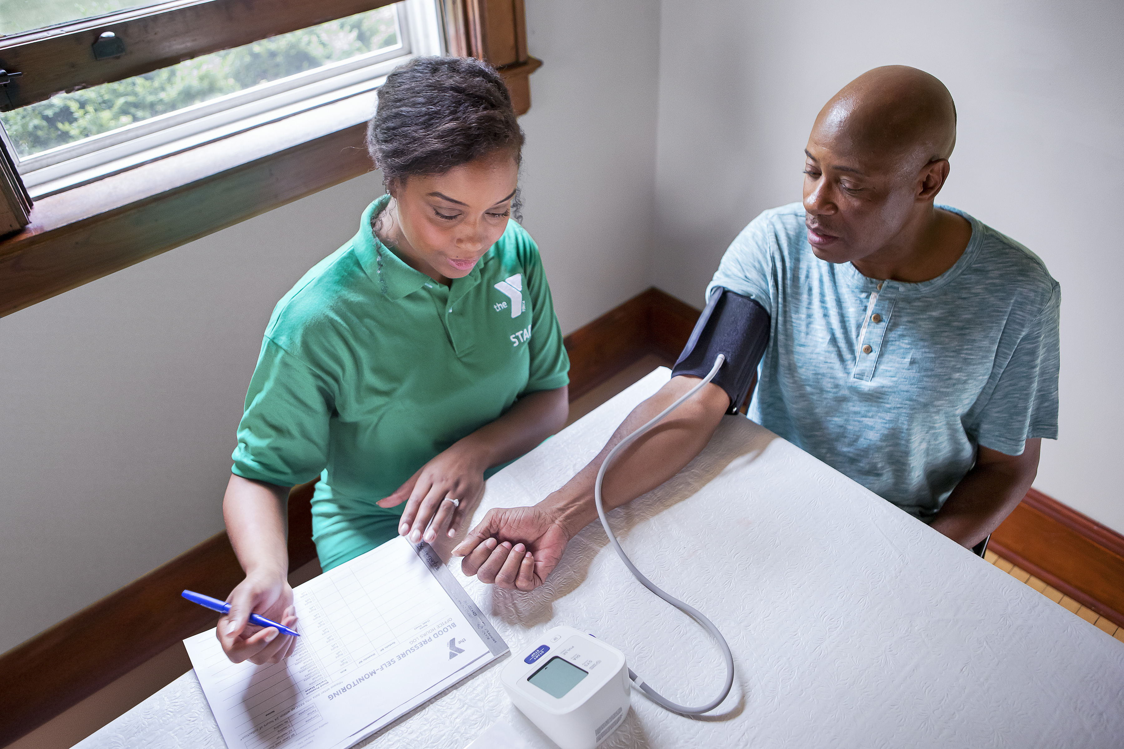 YMCA faculty helping man take blood pressure for diabetes program