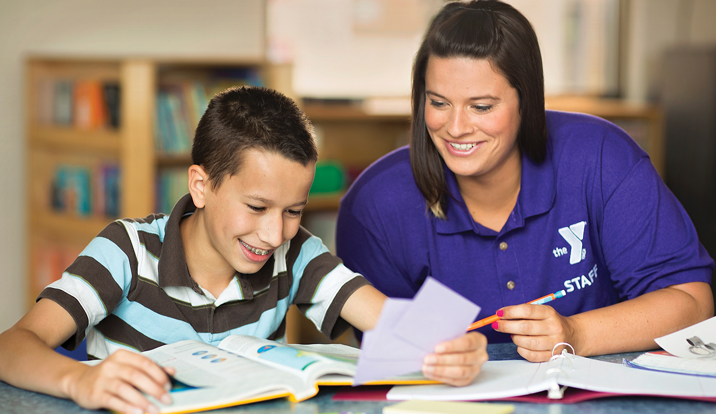 YMCA staff member tutoring young girl
