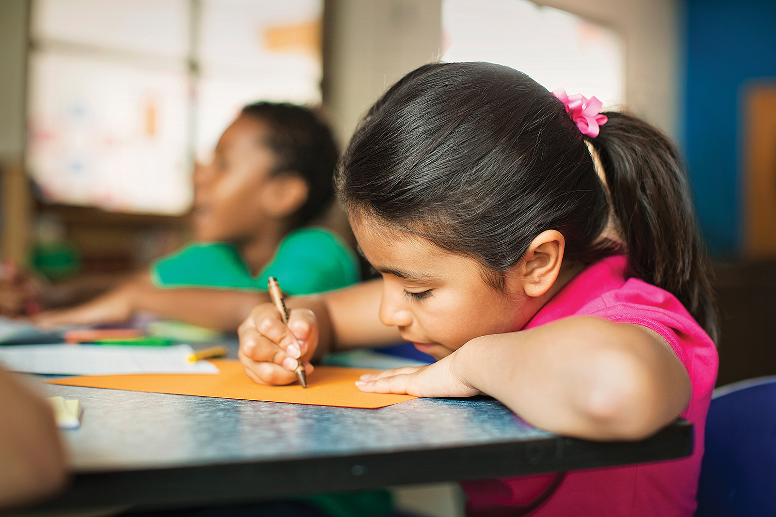 Young children sitting in headstart class at YMCA coloring