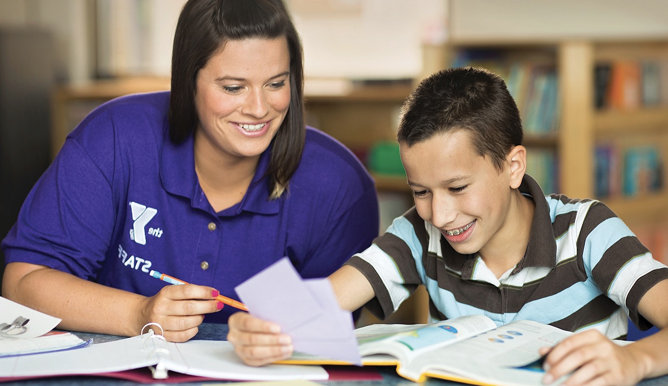YMCA staff member helping student with homework