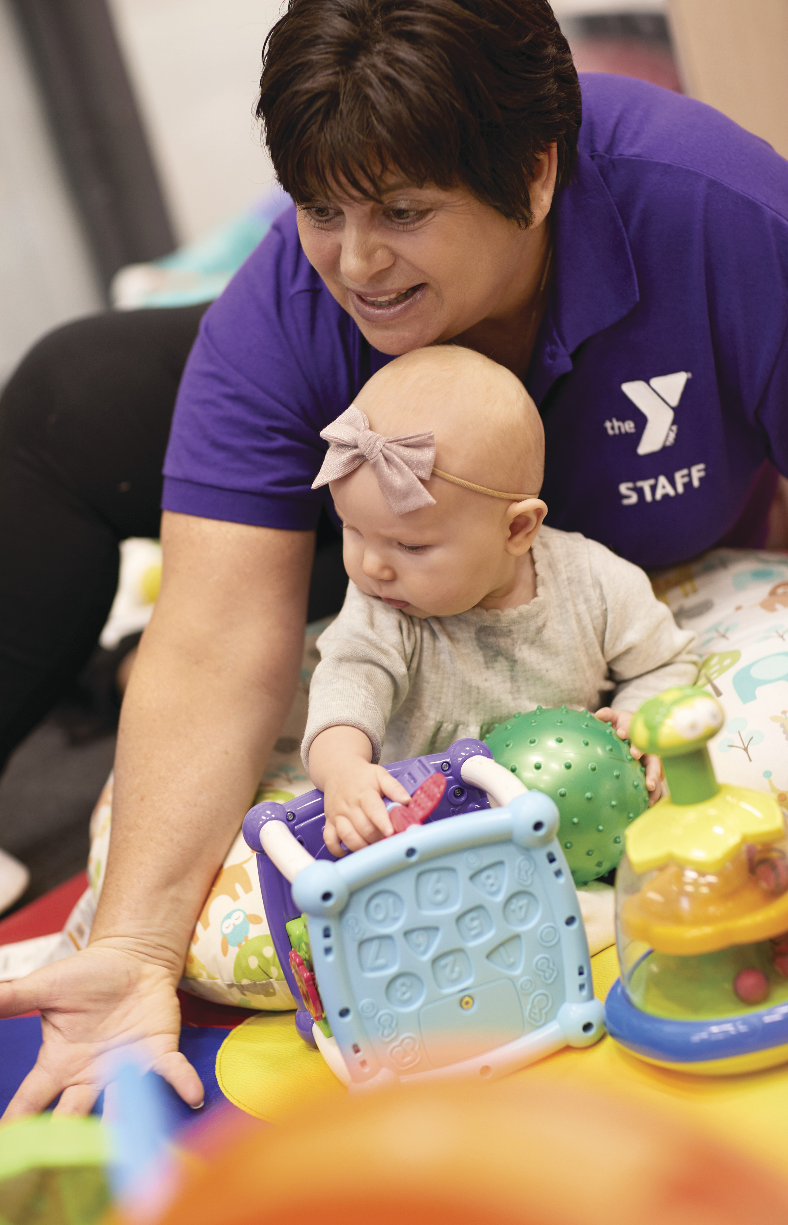Woman holding babydoll during playtime at YMCA