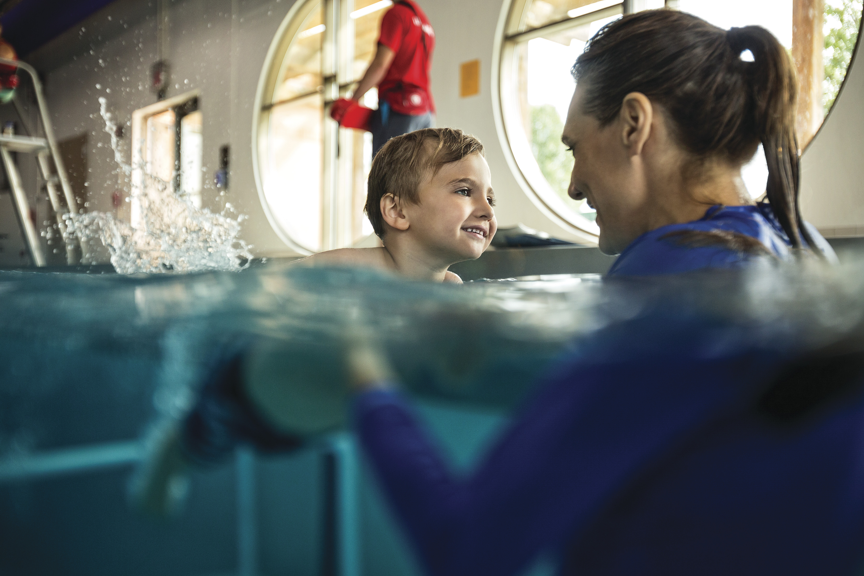 Child and guardian practice water safety during swim classes at YMCA