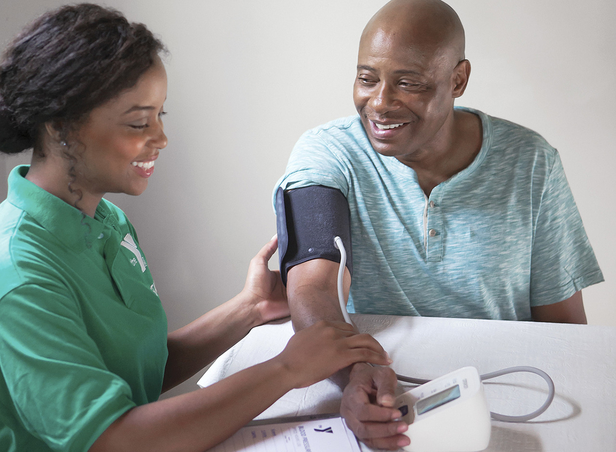 YMCA faculty helping man take blood pressure for diabetes program