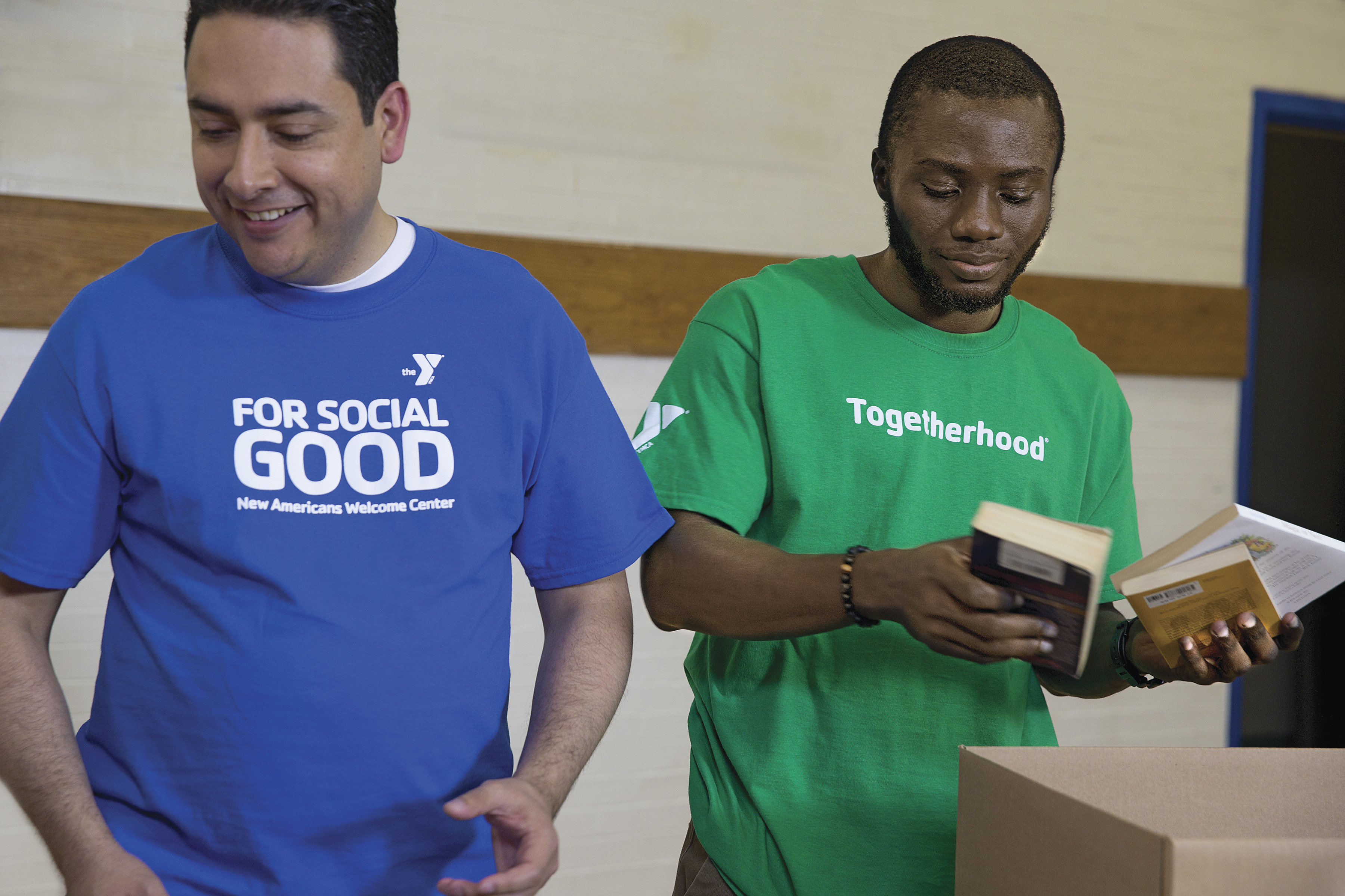 Two men support young people through YMCA