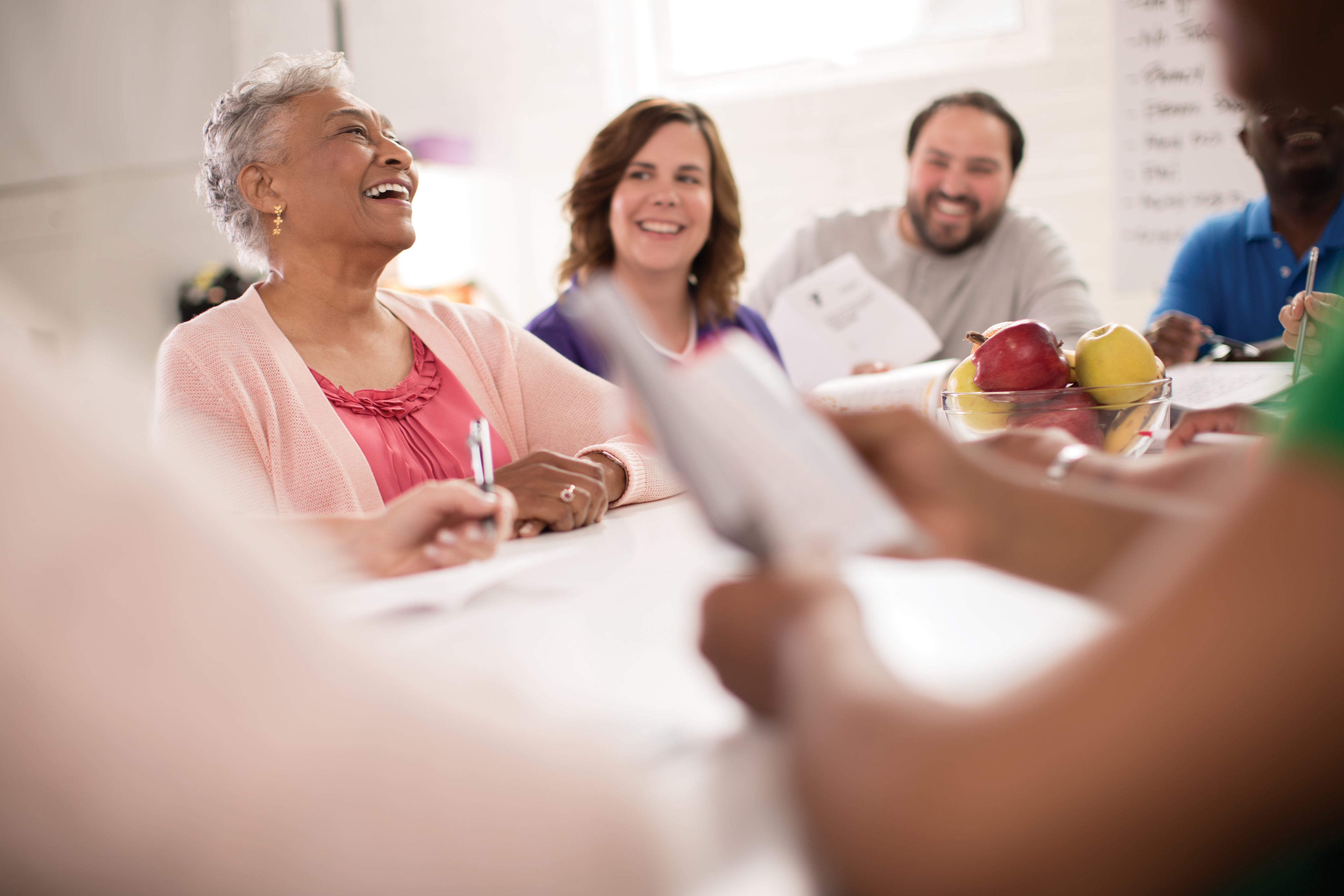 Adults laughing at a conference room table