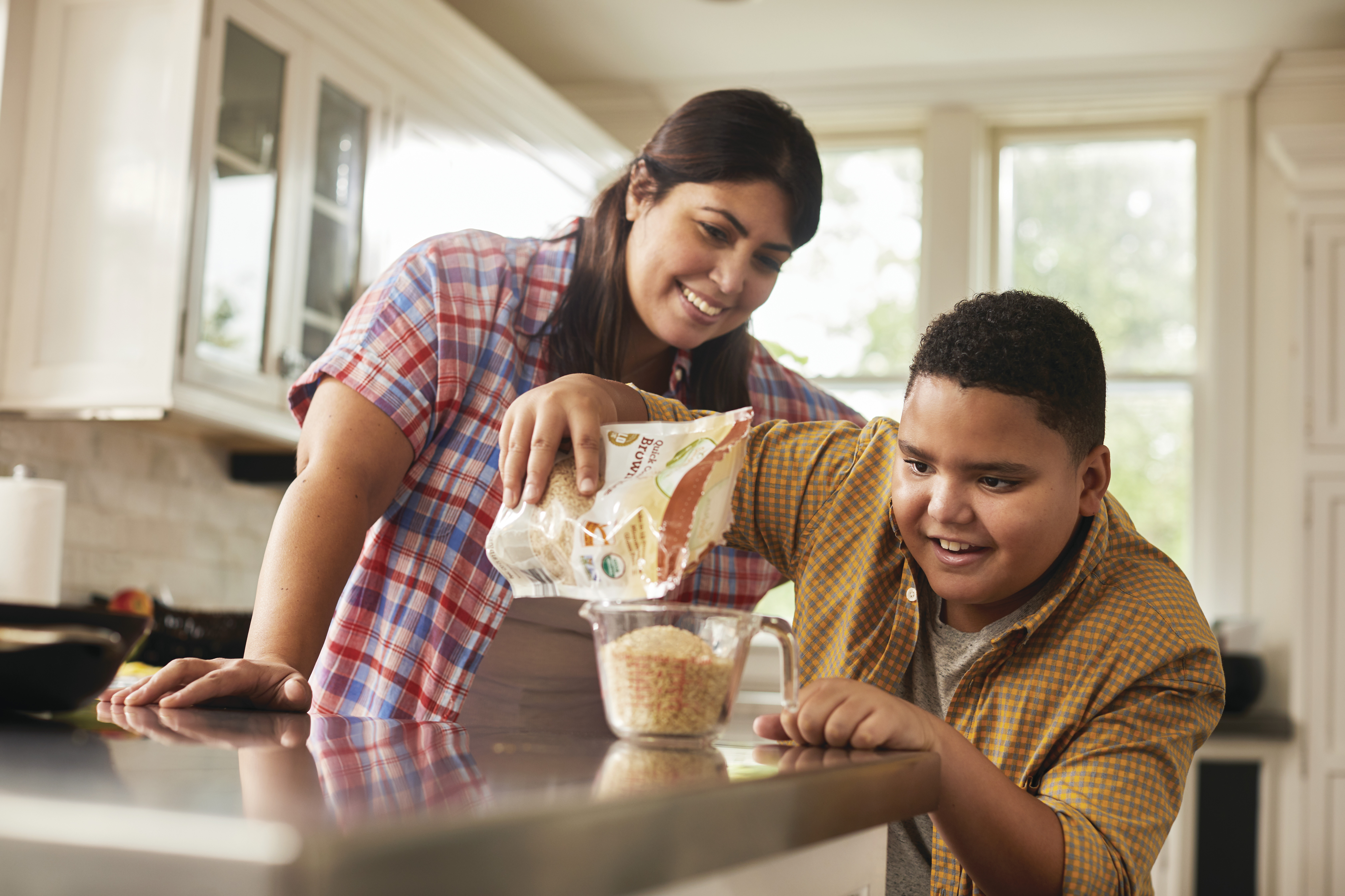 Parent and teen pouring grains in measuring cup