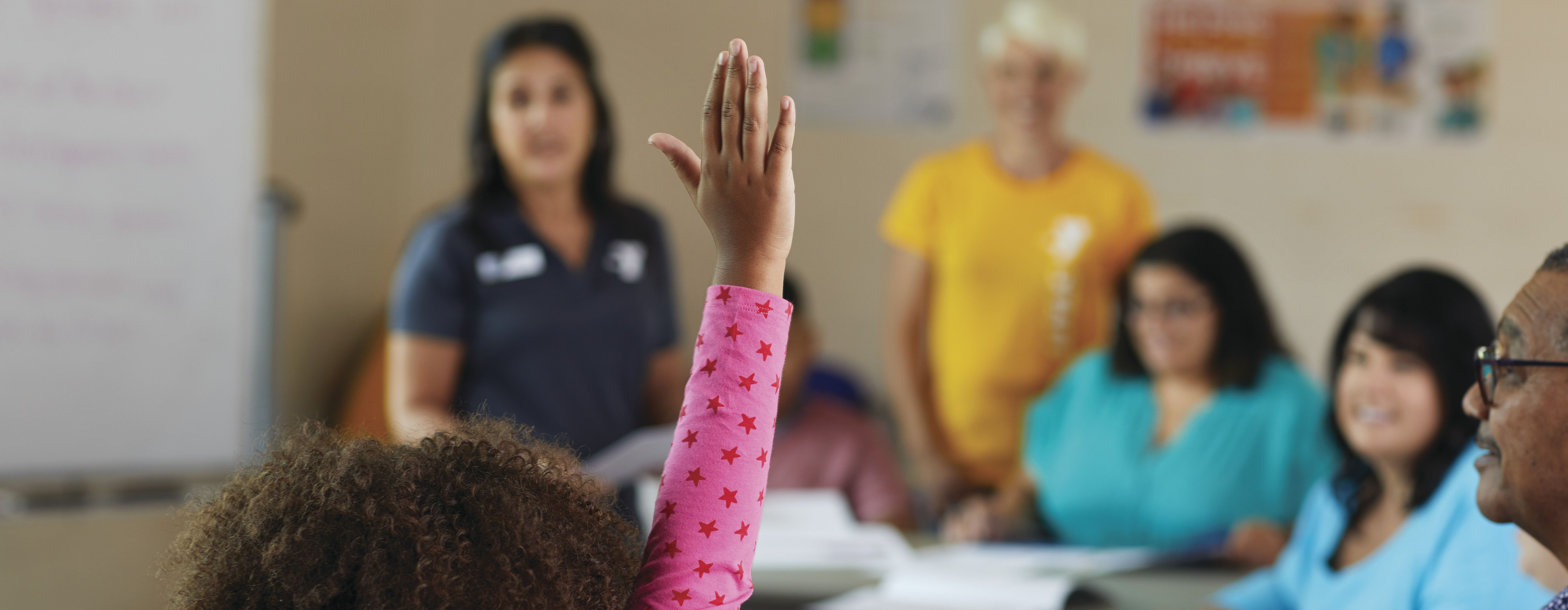 Child raising hand in classroom