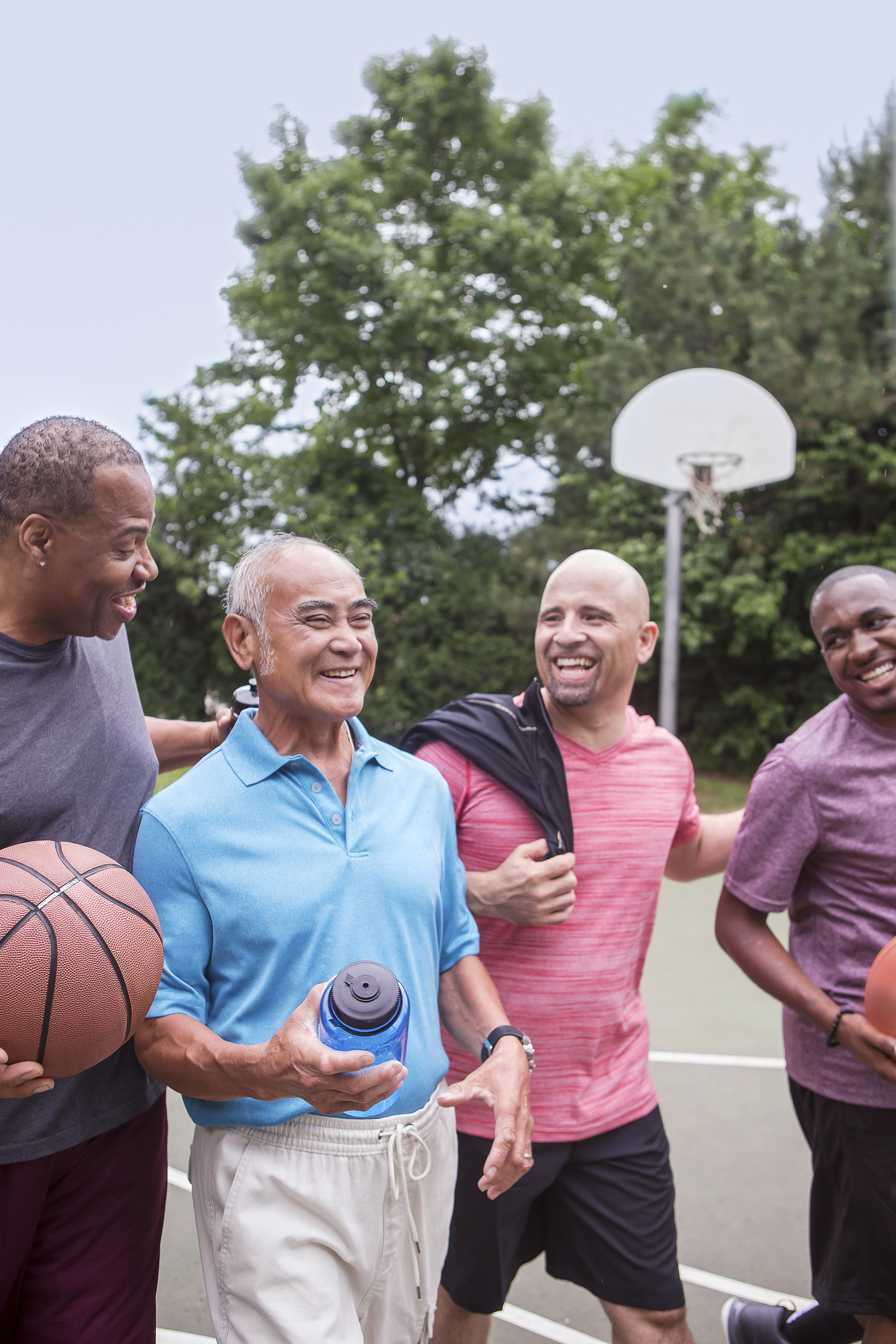 Group of men chatting on the outdoor basketball court