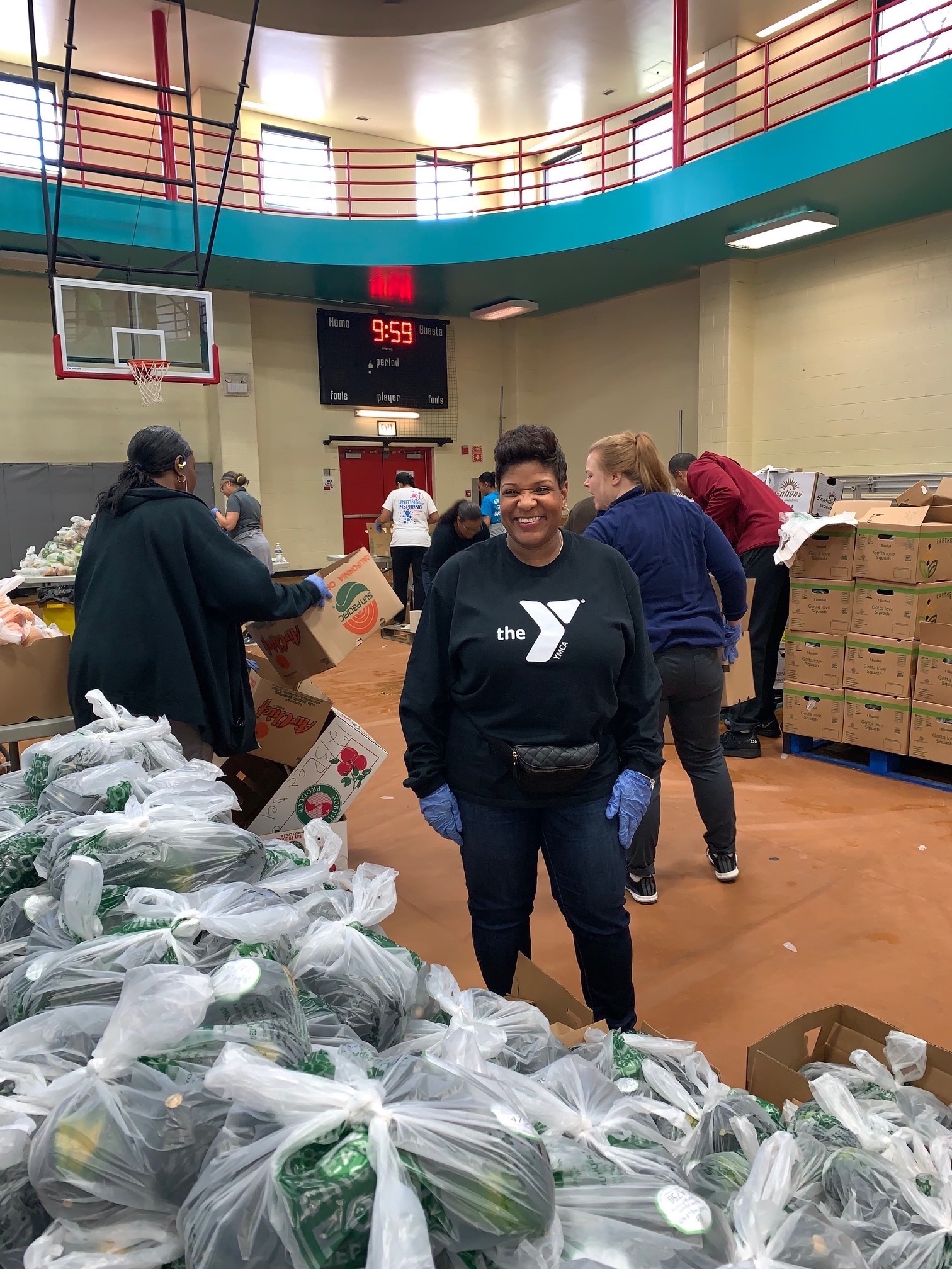 Volunteer in a gym with bags full of donations