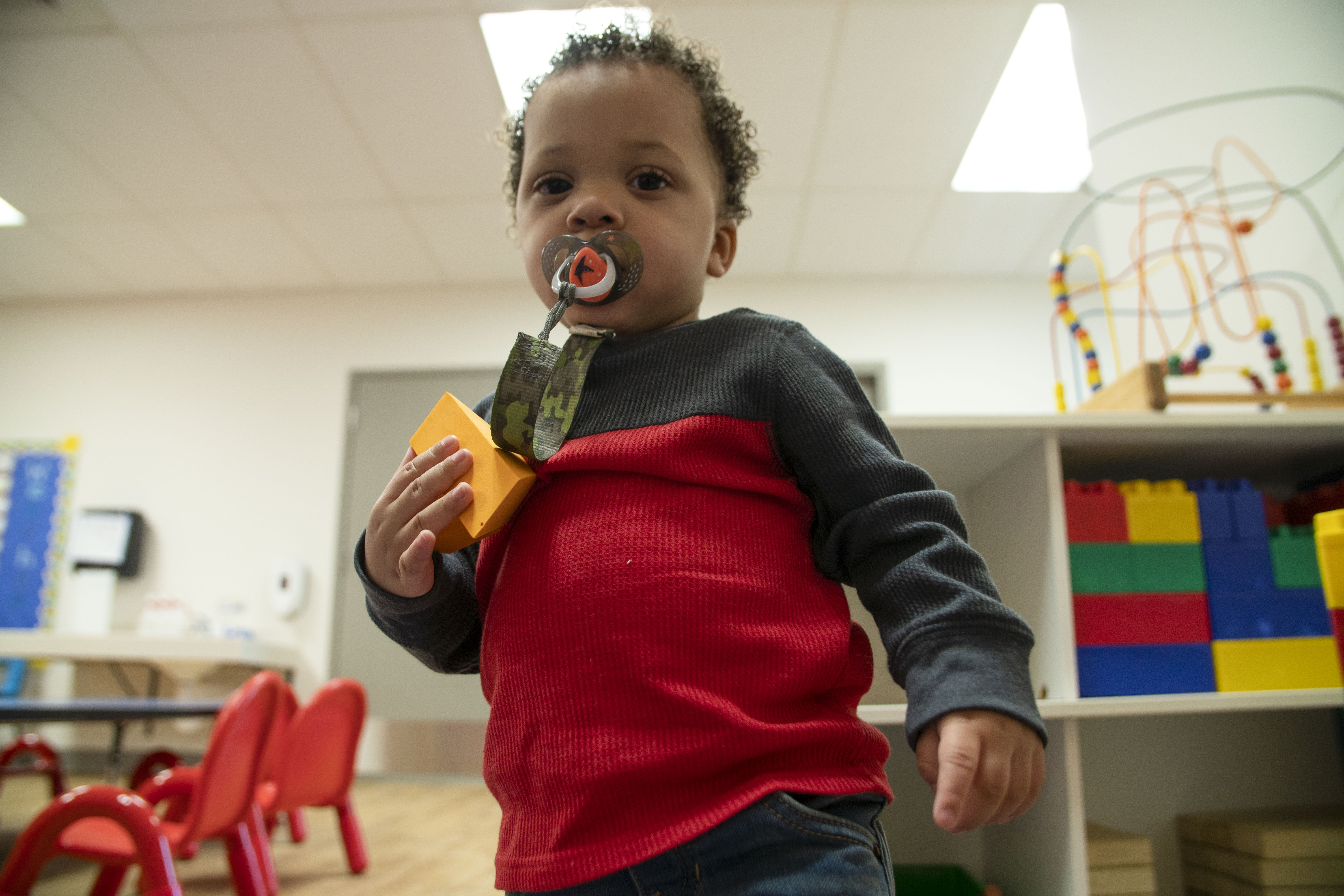 Toddler in playroom at YMCA playing with toys