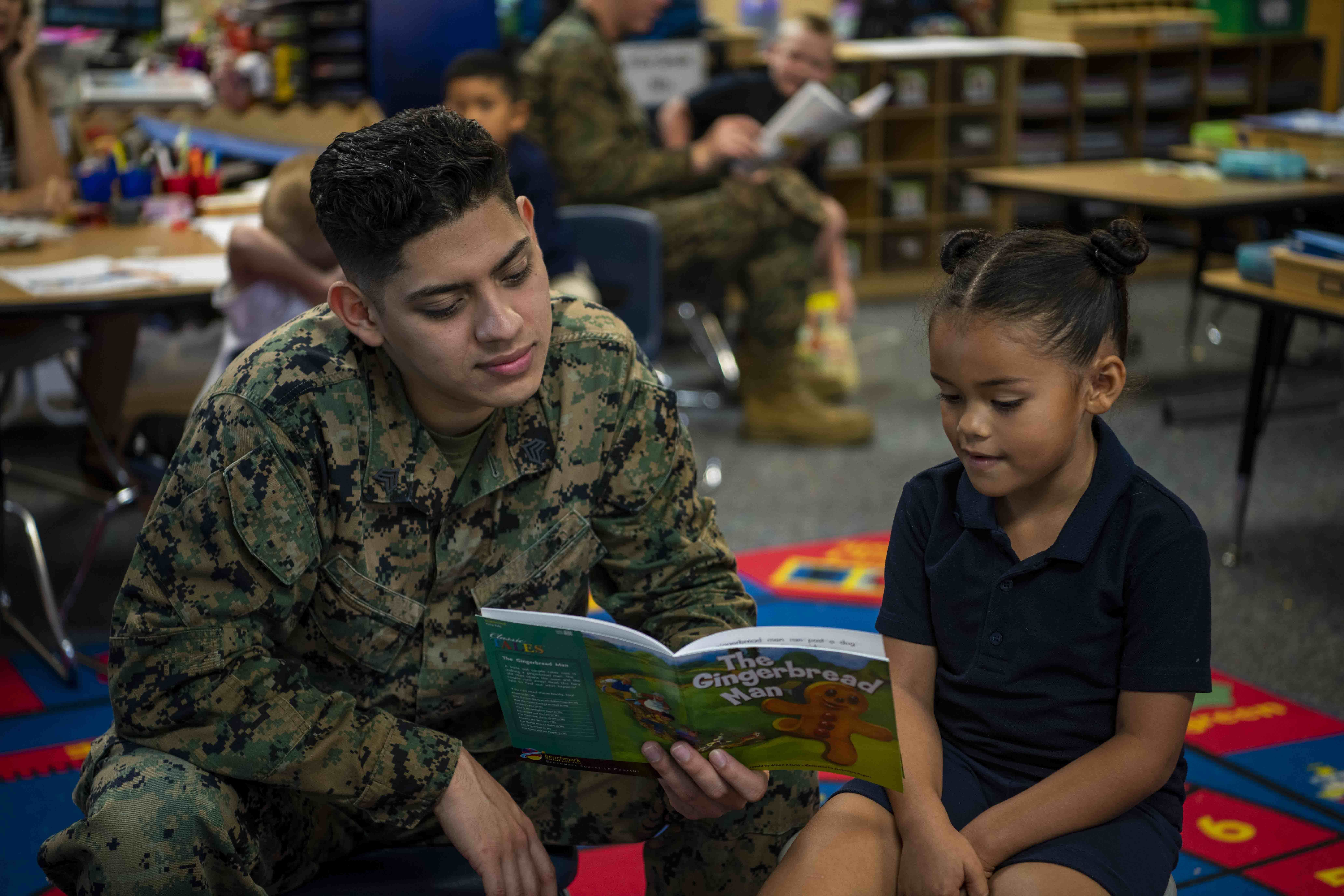 military father reading book with child at YMCA