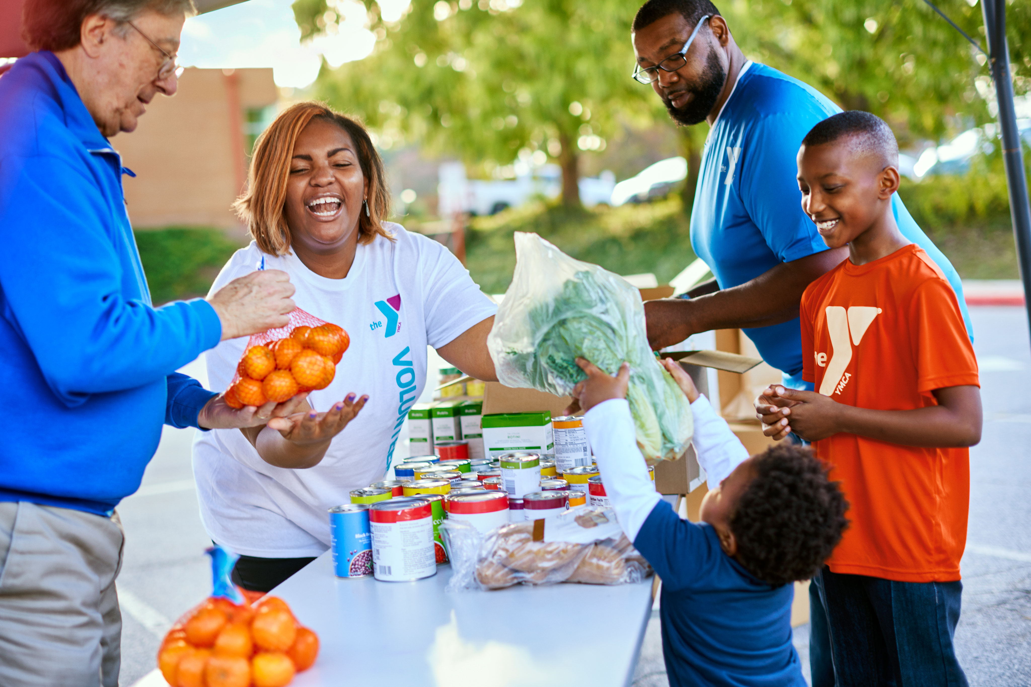 Volunteer family handling fresh produce for Y food drive