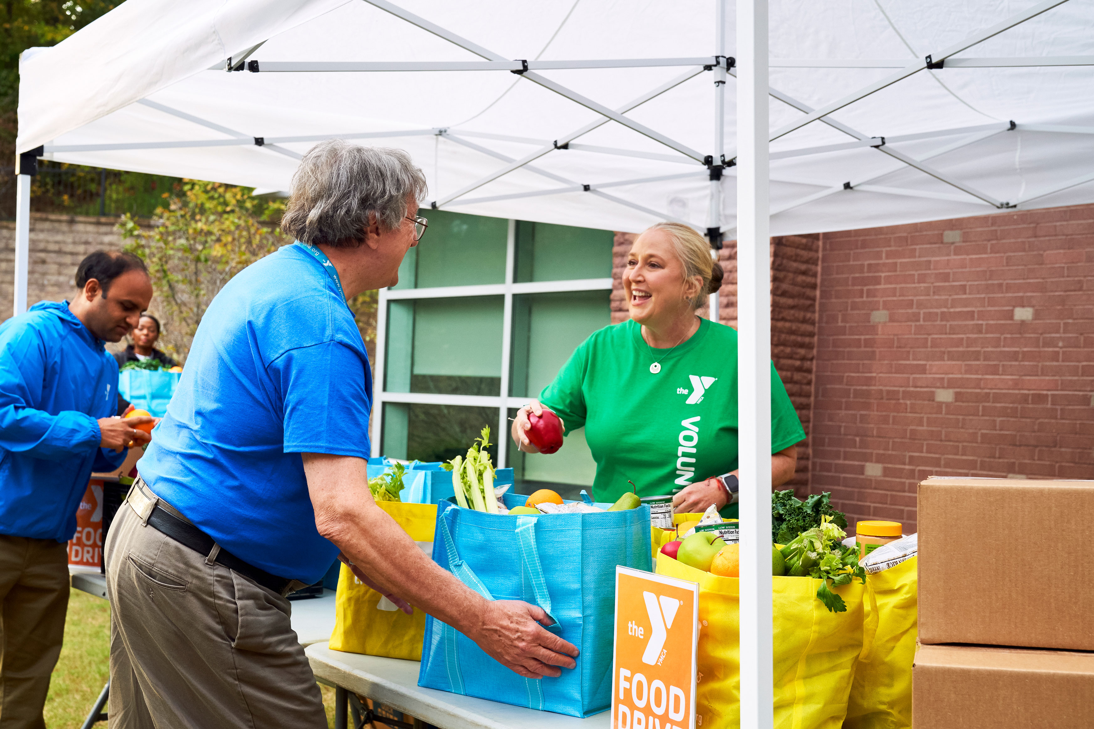 Y volunteers handling fresh produce at food drive