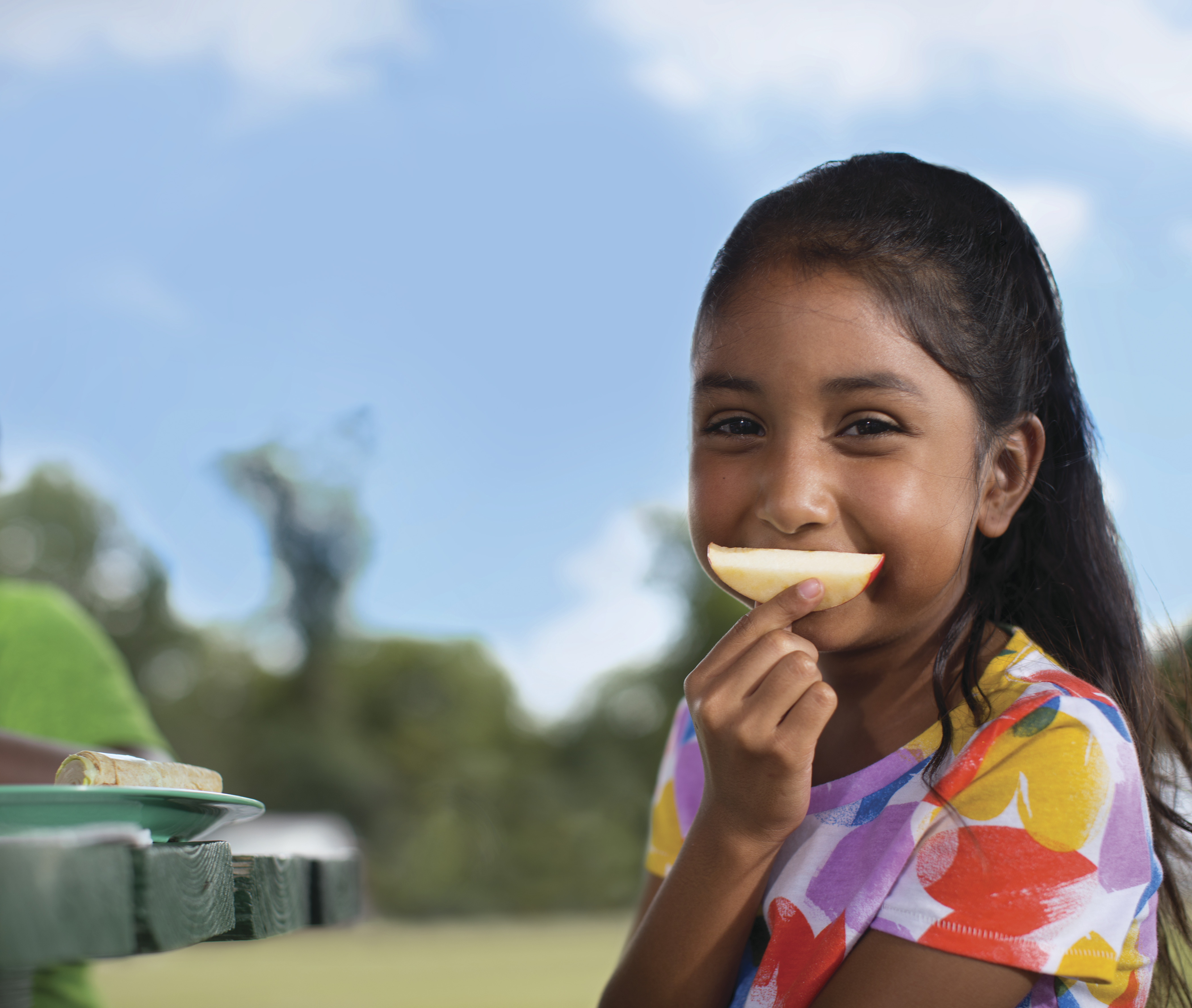 Girl eating a piece of fruit
