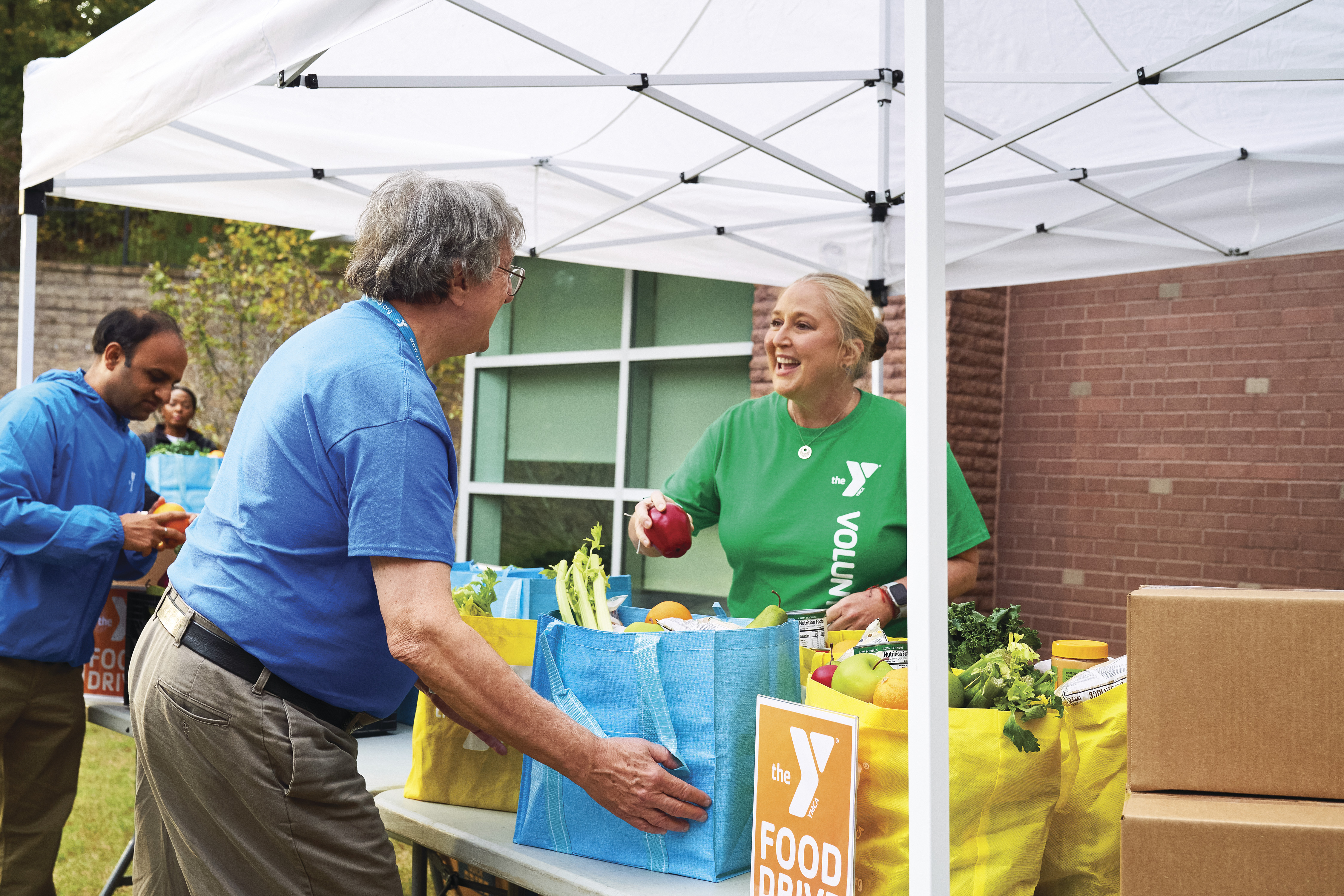 YMCA volunteer handing out food.