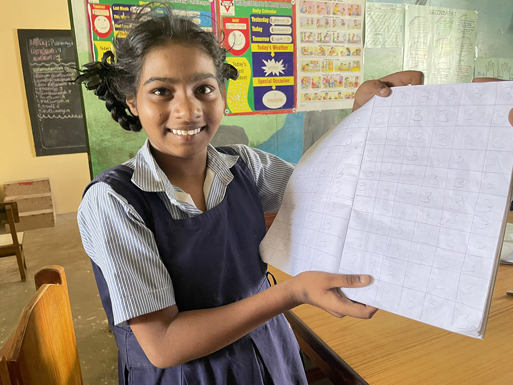Girl holding homework.