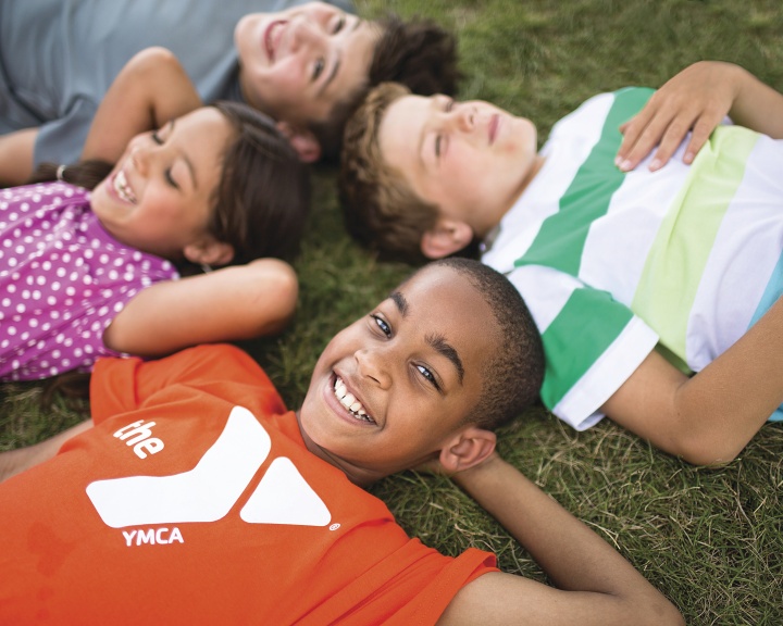 Kids smiling and lying on the grass