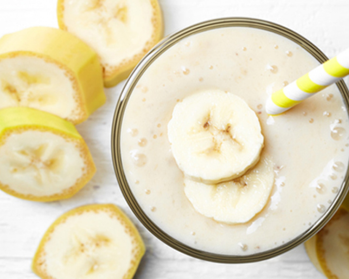 Banana smoothie in a glass with banana slices
