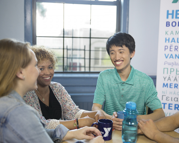 Group of adults sitting around a table smiling