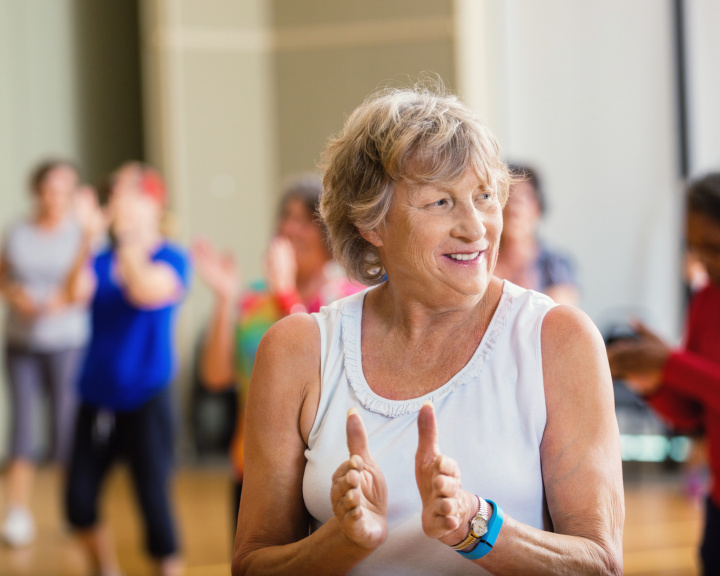 Woman in a group fitness class with others behind her.